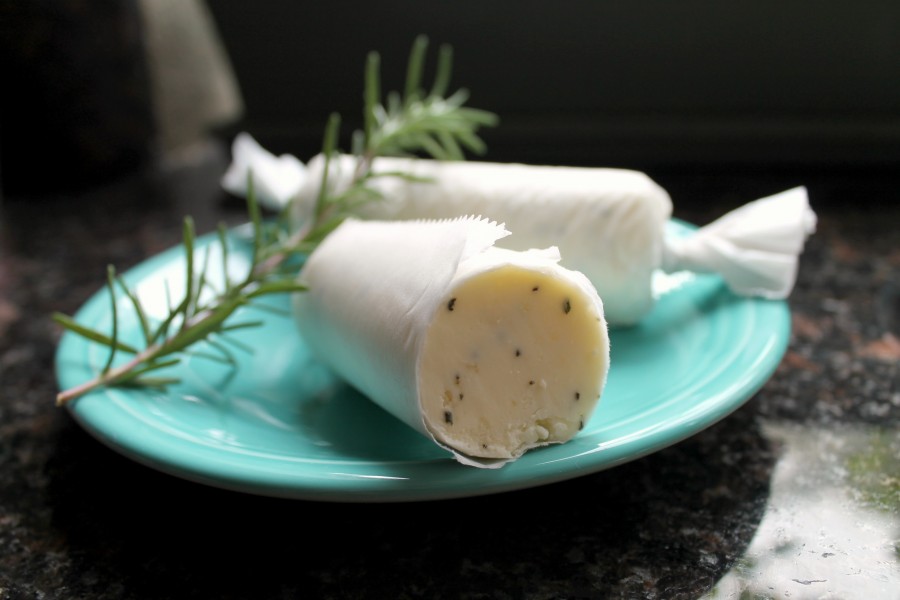 Rosemary compound butter with garlic rolled into a butter roll with parchment paper