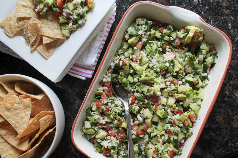 Large batch of ceviche served in a baking dish with tortilla chips on the side.